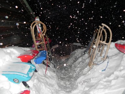 Schlitten und Schneegestöber vor der Hütte